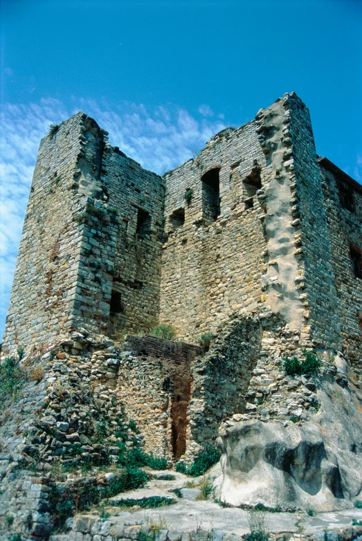 a tall stone building sitting next to a rock cliff