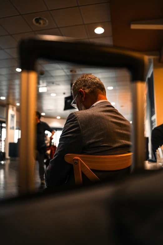 a man in glasses is sitting on a chair