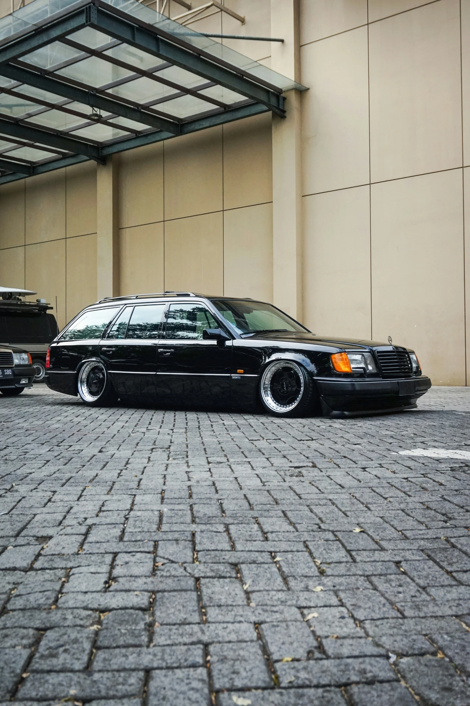 a black car parked in front of a tall building