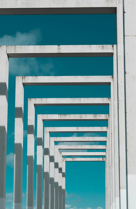 rows of white pillars in front of a sky with a blue sky