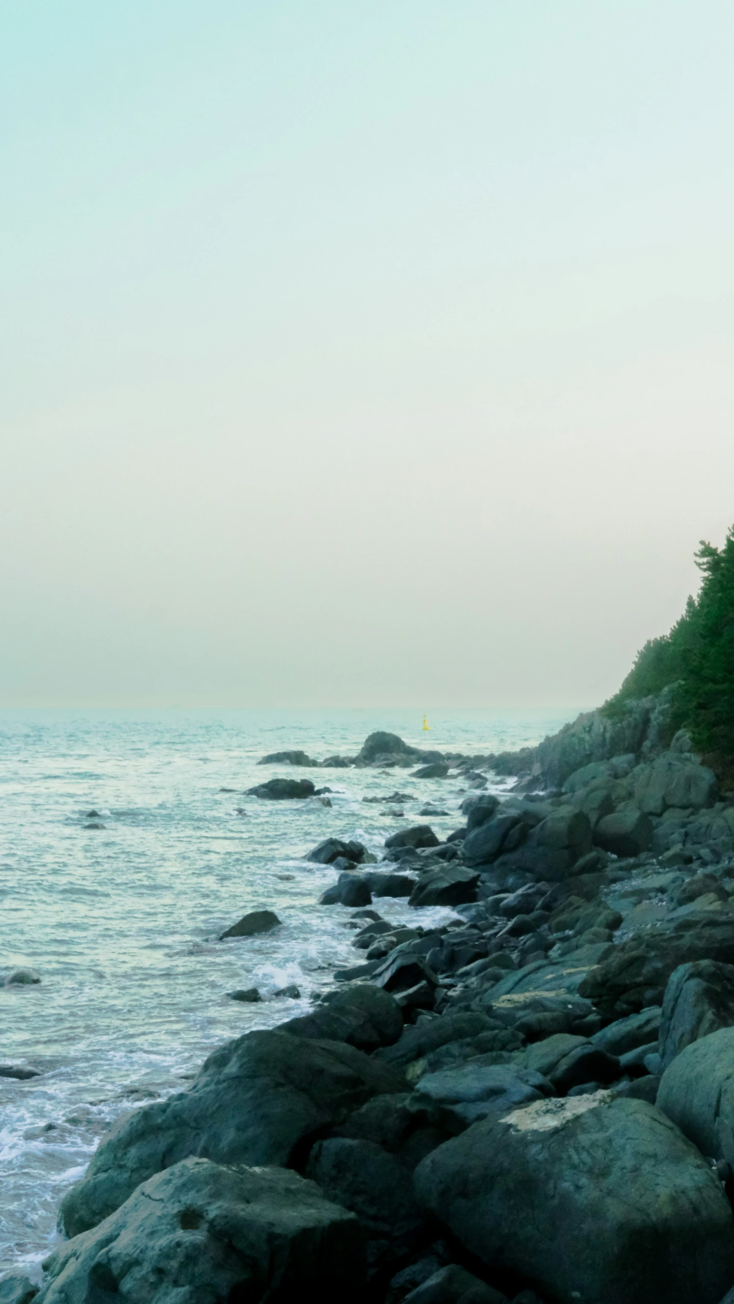 an old lighthouse sits on a rocky shoreline