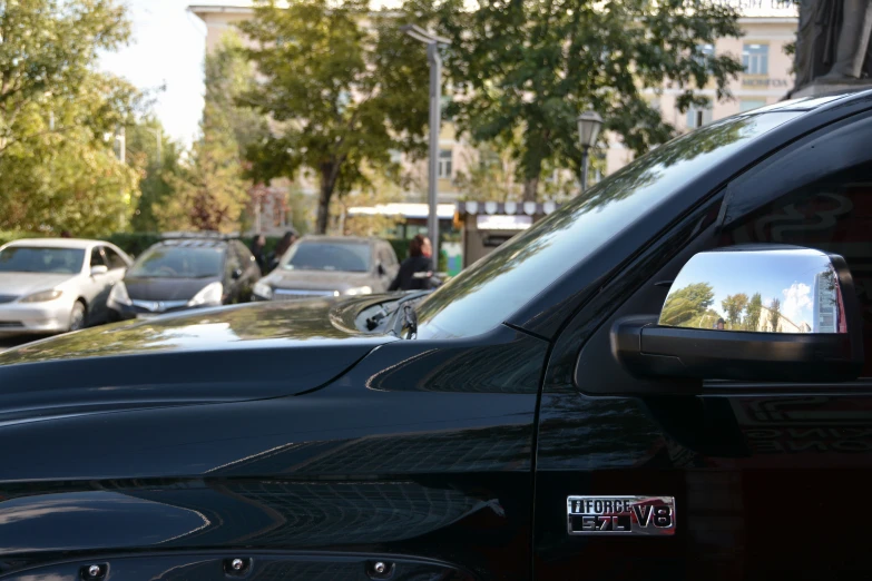 a car with its side mirror missing parked in front of cars