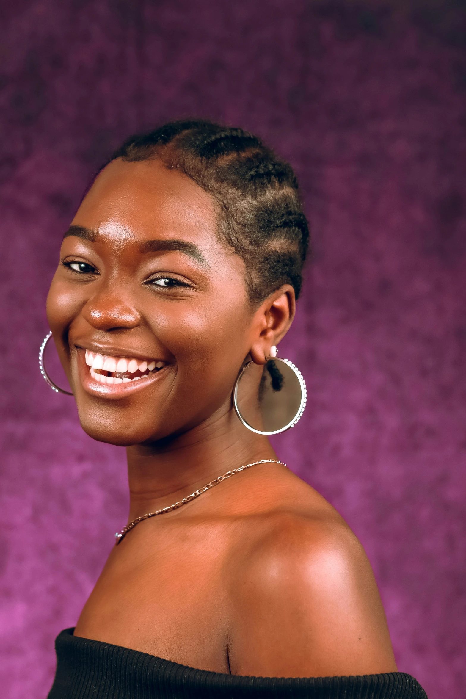 an african american woman smiling in a purple background