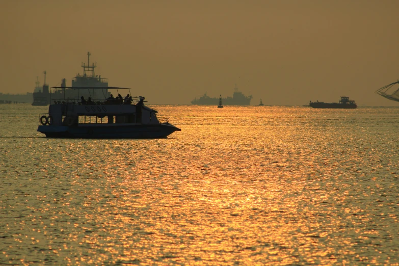 the sun setting in the ocean off of a boat