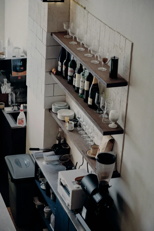 an organized wine cellar containing various bottles and glasses