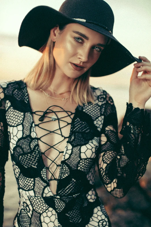 woman in black hat smoking cigarette while wearing sheer dress and matching top