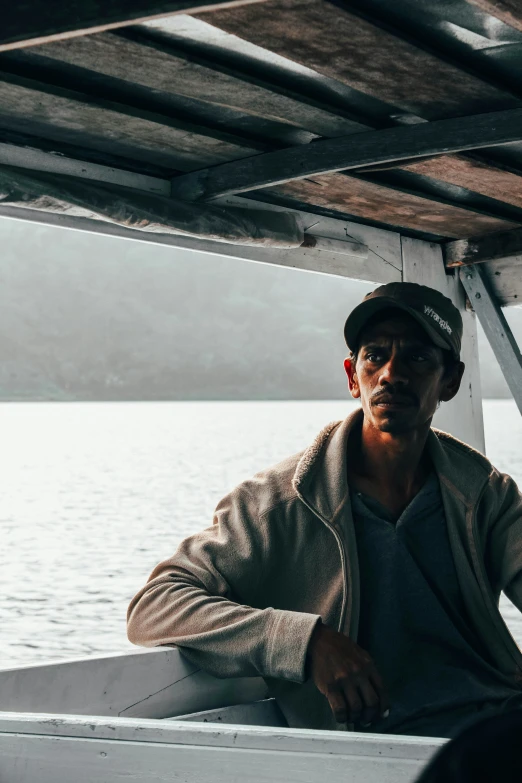 a man standing next to an ocean under a wooden structure