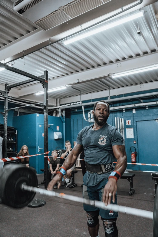 a man stands in the gym holding his hand on his hip