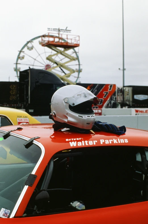 a helmet sits on top of the hood of a red car