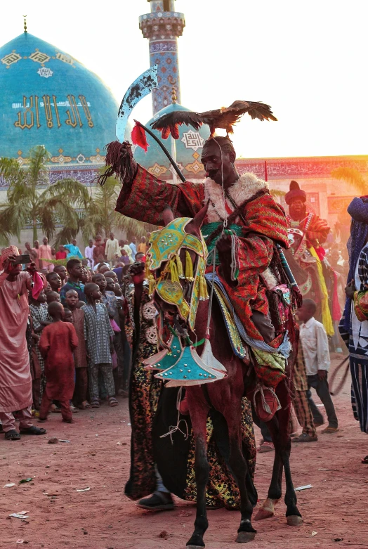 a man in traditional costume riding on a camel