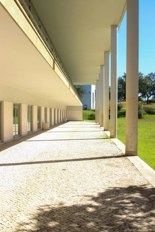 a row of columns next to green grass