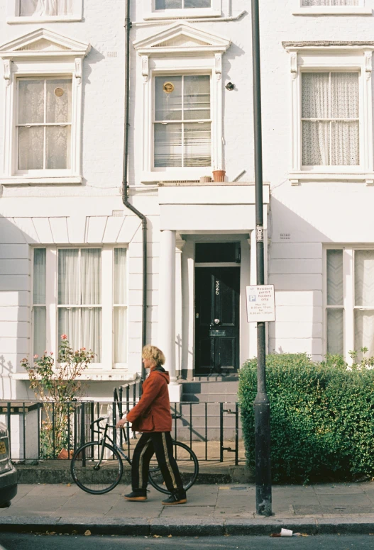 a lady walking by a bicycle on the street