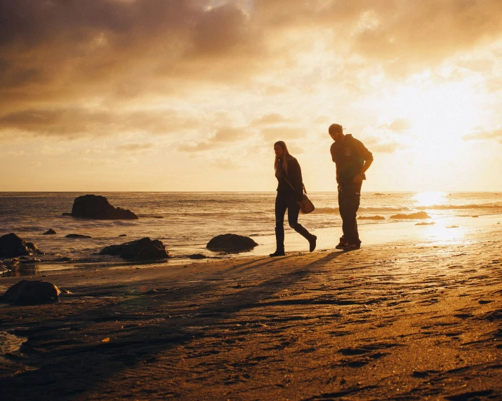 a couple of people that are standing in the sand