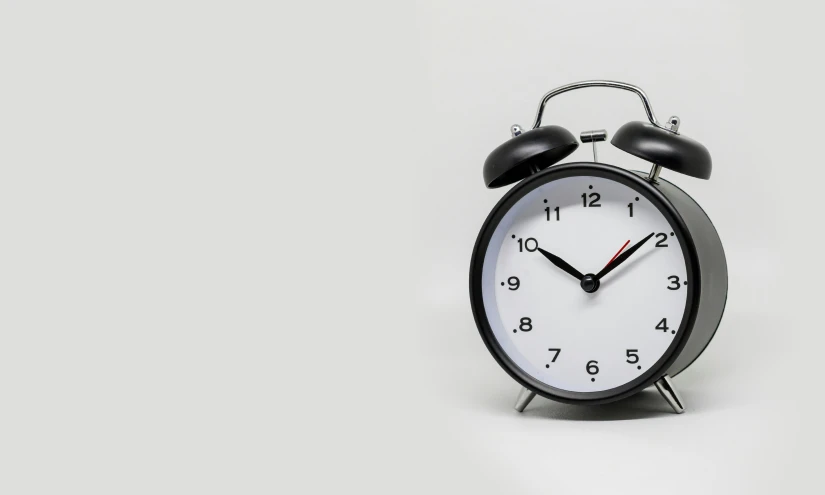 a metal clock sitting on top of a white table