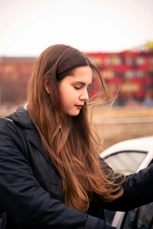 a beautiful young woman standing in front of a white car