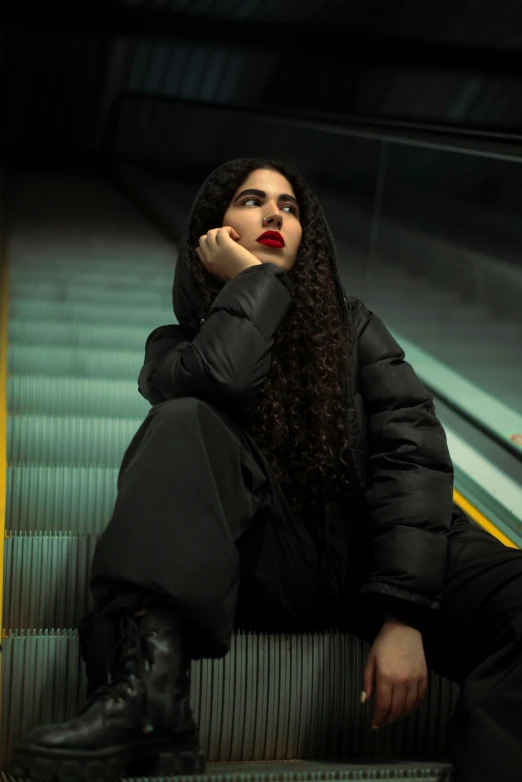 a woman sitting down wearing boots and jacket