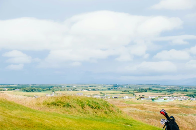 a person holding onto their kite on top of a grass covered hill