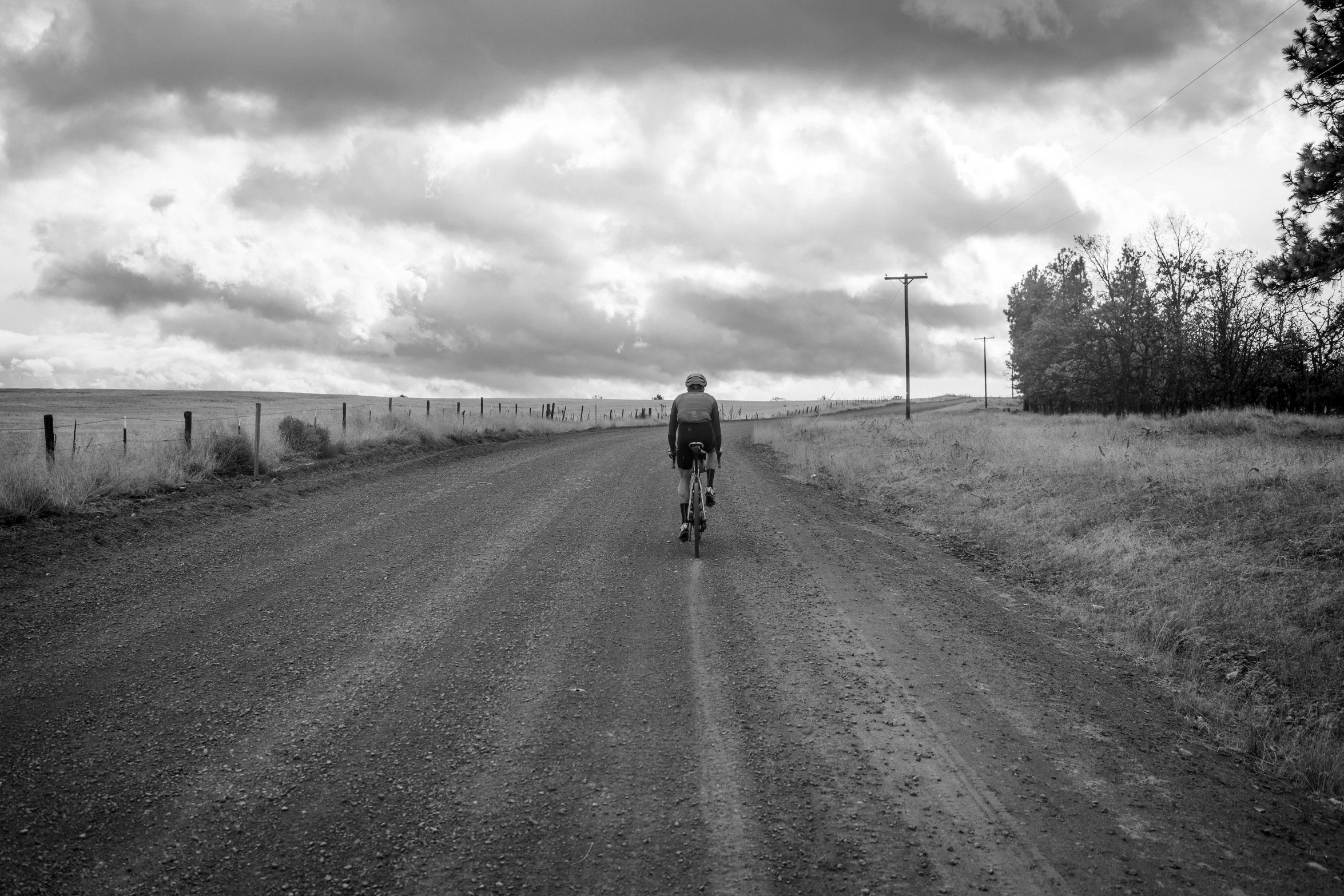 person walking down the road near a fence