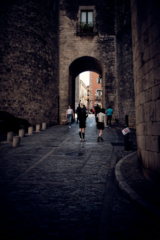 two people walk in the tunnel under an arch