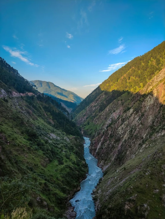 a river flows through a valley near some mountains