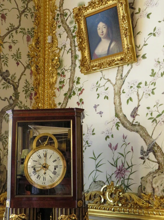 an ornate wallpaper with a painting next to an old clock
