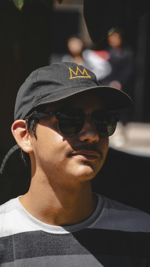 man with sunglasses and baseball cap staring ahead