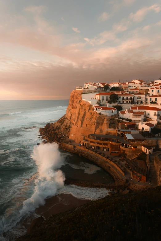 view from hillside overlooking ocean and small town on cliff edge