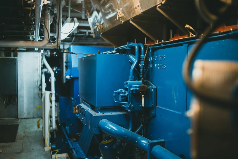 a very large blue machine sitting next to a building