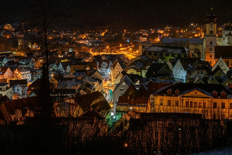 an aerial view of a nighttime scene of buildings, lights and trees