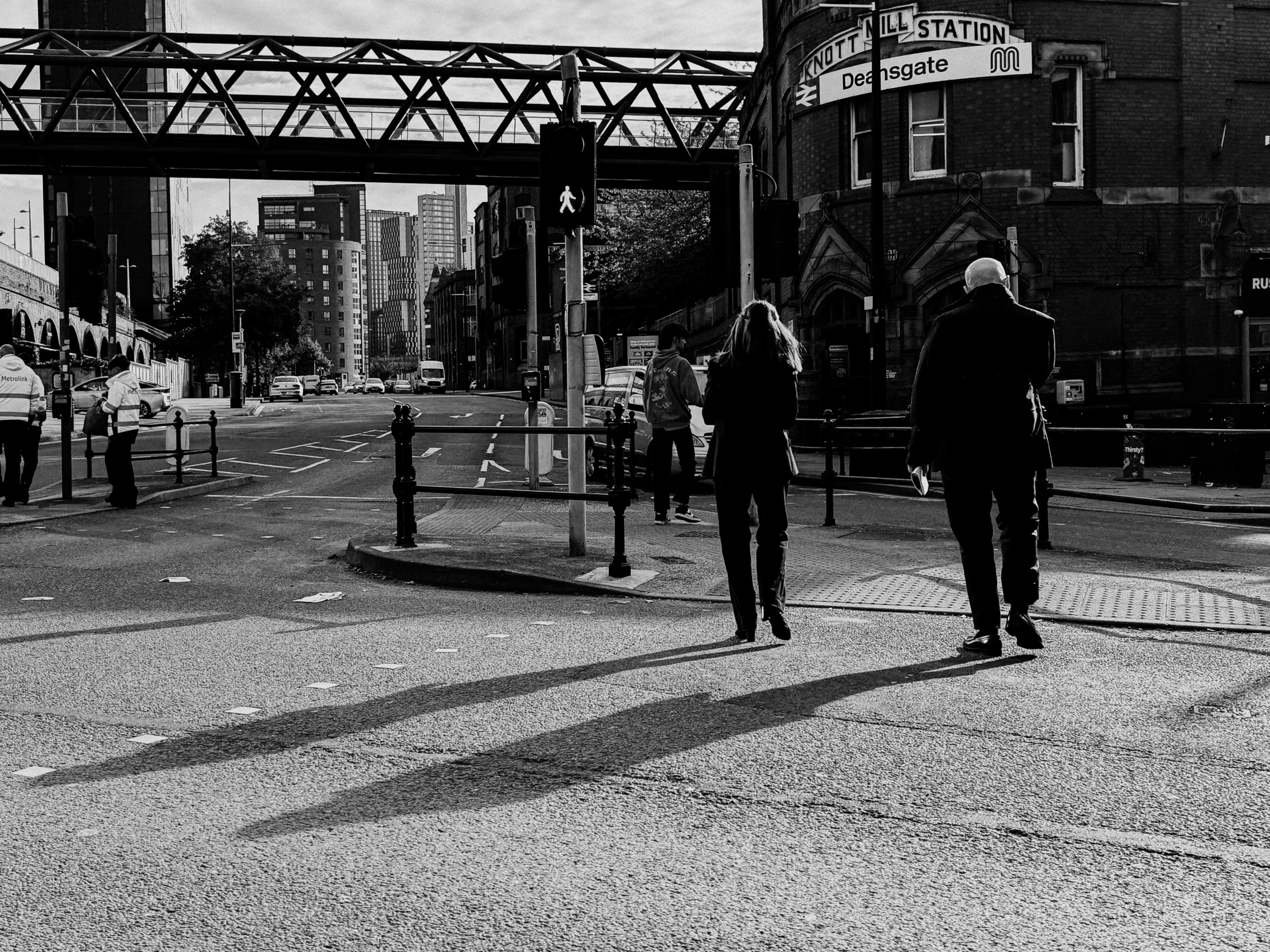 a man and a woman walking across an empty road