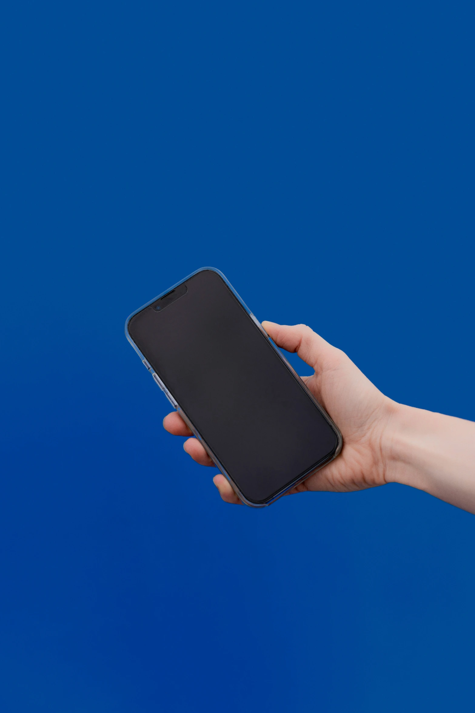 a person holding a cell phone against a blue background