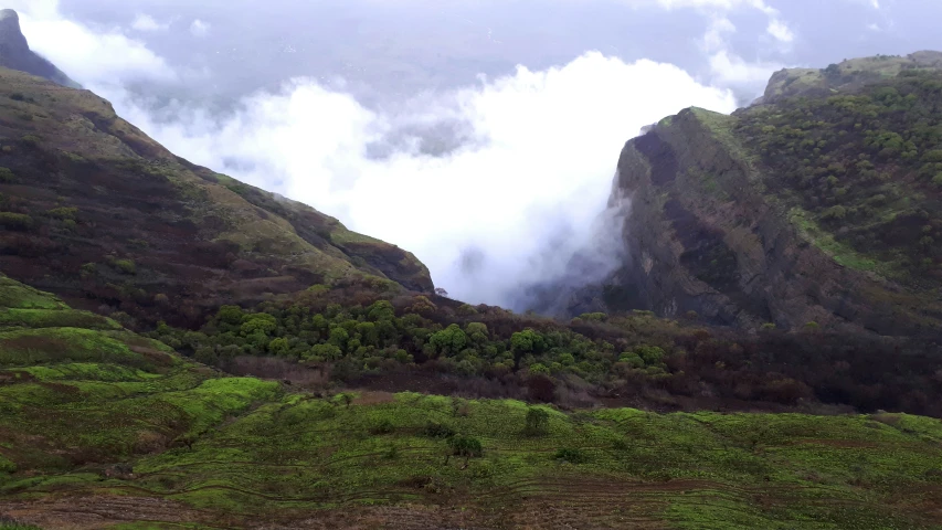 the mountains are very high with fog in the air