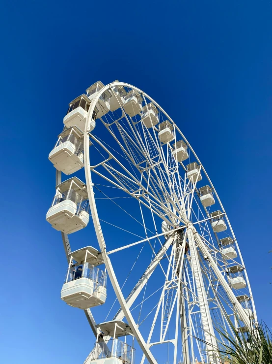 the ferris wheel is in the middle of the blue sky