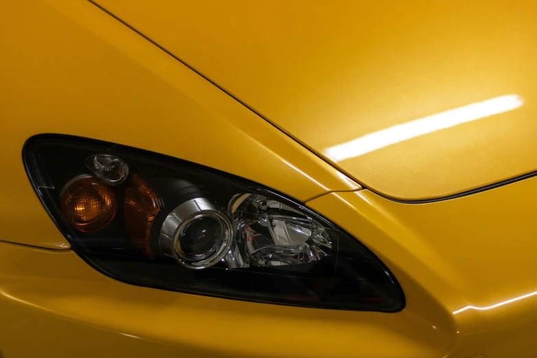 a close up of a yellow sports car's license lights