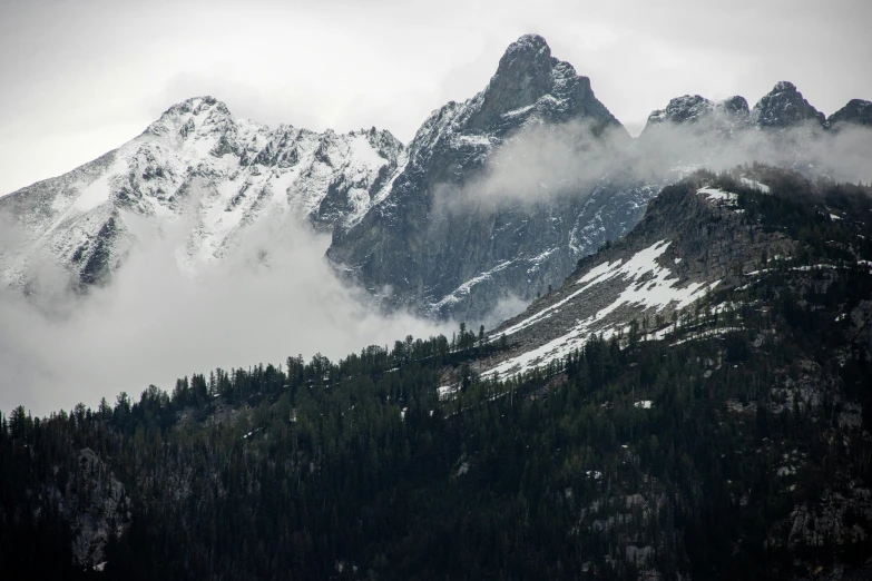 an almost cloudy day at the top of a mountain with snow on it