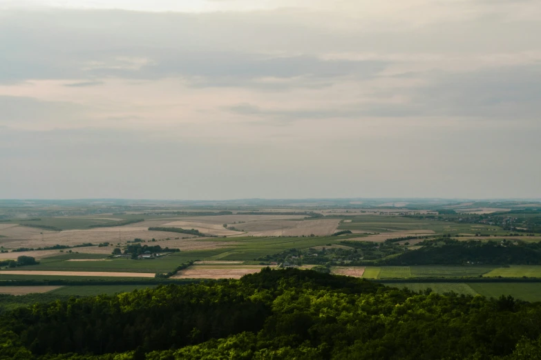 a landscape with fields and mountains in the distance