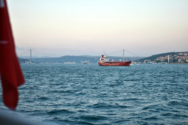 a large boat in the water next to a bridge