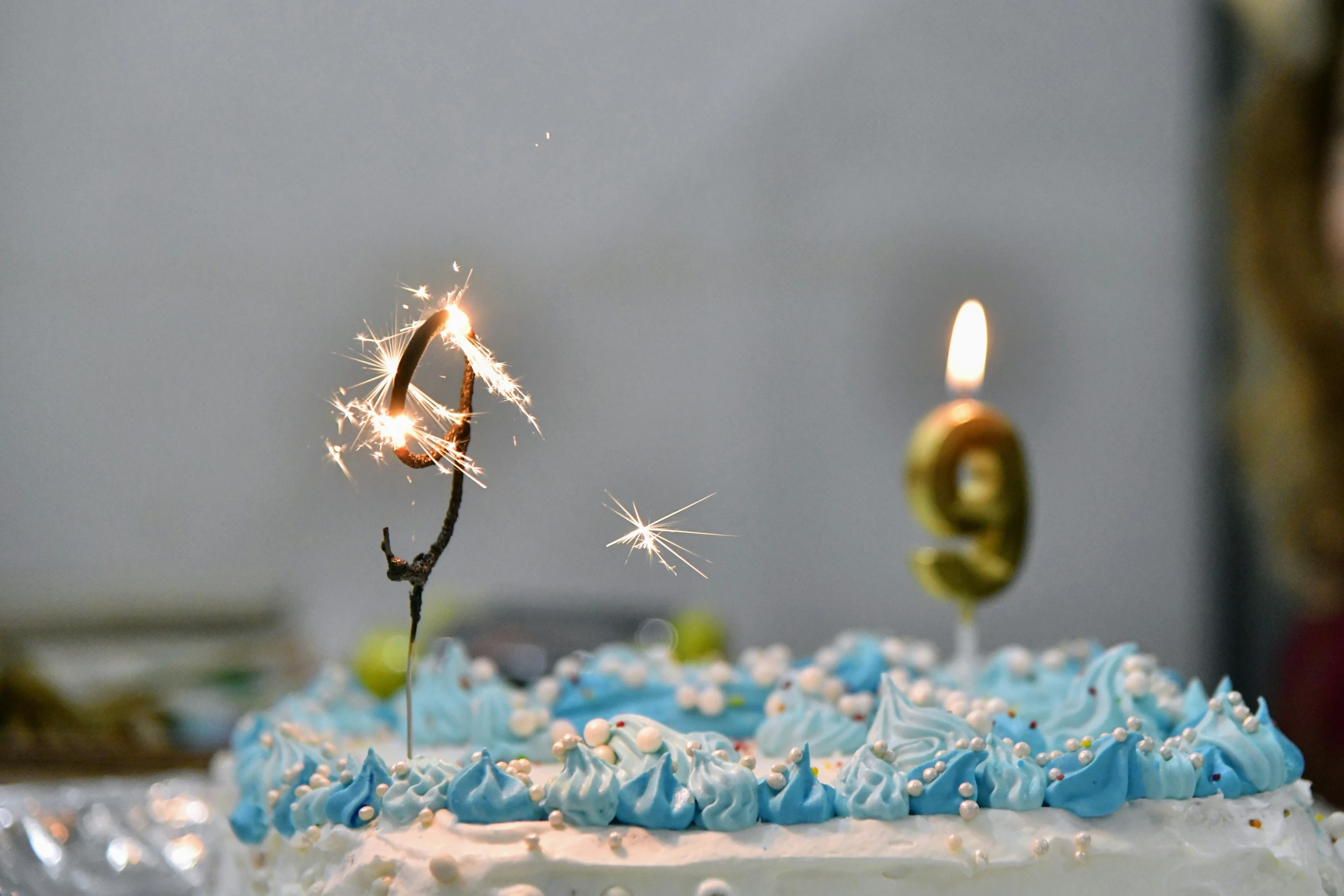 a birthday cake with blue frosting and sparklers