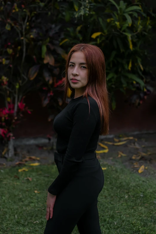 a woman with red hair and black top