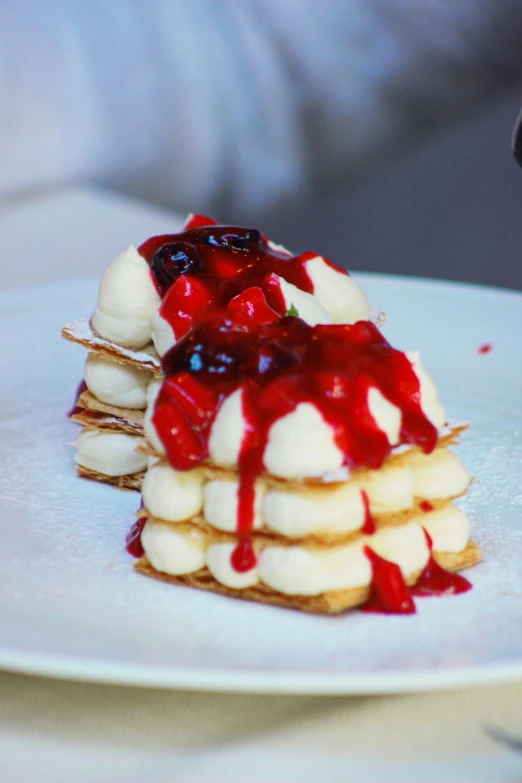 a stack of food with cream, strawberry sauce and banana slices