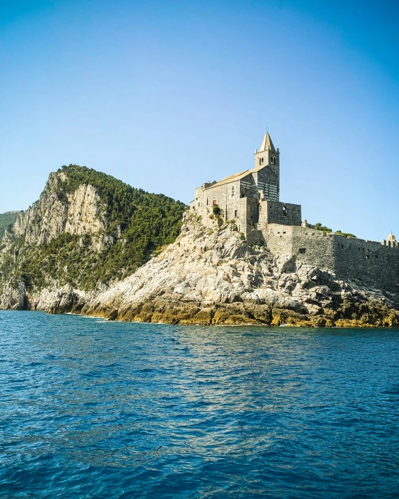 a castle sitting on top of a rocky hill above the ocean