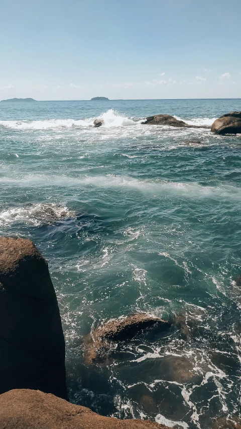 there are rocks on the ocean floor and a rock outcropping near them