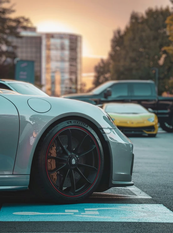 a silver sports car parked next to other cars