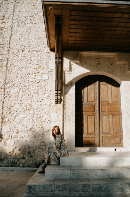 an image of woman sitting outside of church