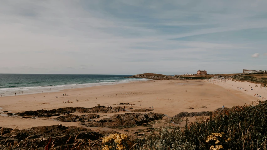 a sandy beach near an ocean in the middle of the day