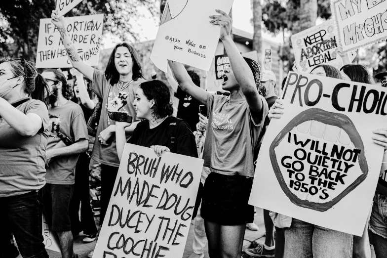 people holding signs and holding papers in the street