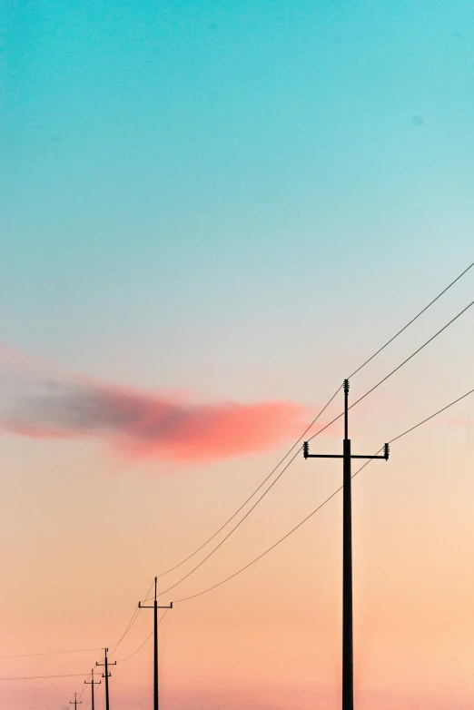 a view of two telephone poles on an empty road