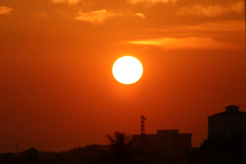 the sun is rising in the sky over some buildings