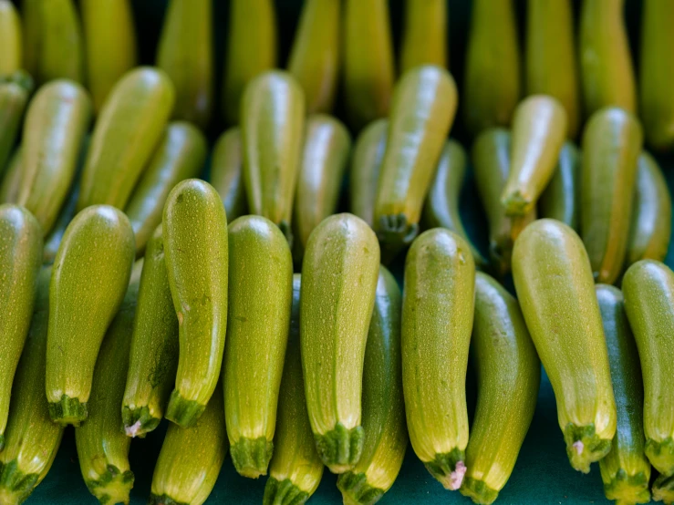 several bunches of small cucumbers stacked up together