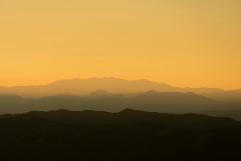 the view of the mountains in front of a hazy sky